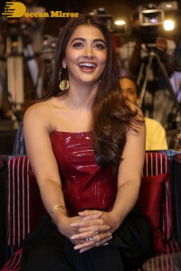 Pooje Hegde in a red shoulderless top and black pants while attending a movie funciton