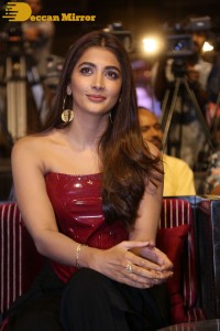 Pooje Hegde in a red shoulderless top and black pants while attending a movie funciton