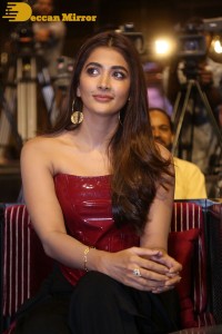 Pooje Hegde in a red shoulderless top and black pants while attending a movie funciton