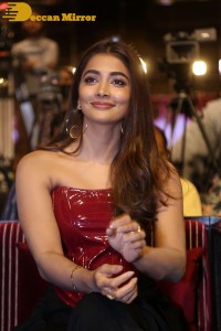Pooje Hegde in a red shoulderless top and black pants while attending a movie funciton