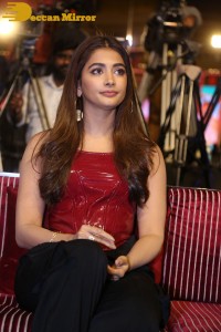 Pooje Hegde in a red shoulderless top and black pants while attending a movie funciton