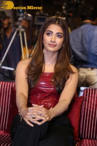 Pooje Hegde in a red shoulderless top and black pants while attending a movie funciton