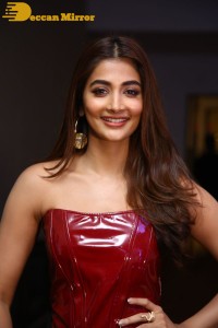 Pooje Hegde in a red shoulderless top and black pants while attending a movie funciton