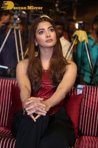 Pooje Hegde in a red shoulderless top and black pants while attending a movie funciton