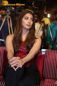 Pooje Hegde in a red shoulderless top and black pants while attending a movie funciton