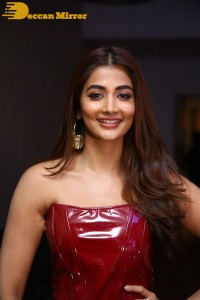 Pooje Hegde in a red shoulderless top and black pants while attending a movie funciton