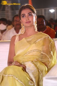 Actress Pooja Hegde in a yellow saree while attending the pre-release event of the Telugu movie Acharya