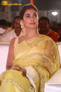 Actress Pooja Hegde in a yellow saree while attending the pre-release event of the Telugu movie Acharya
