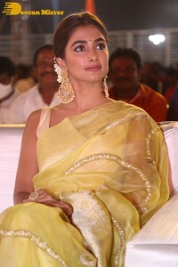 Actress Pooja Hegde in a yellow saree while attending the pre-release event of the Telugu movie Acharya