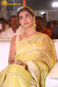 Actress Pooja Hegde in a yellow saree while attending the pre-release event of the Telugu movie Acharya