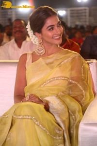 Actress Pooja Hegde in a yellow saree while attending the pre-release event of the Telugu movie Acharya