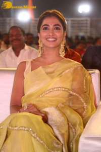 Actress Pooja Hegde in a yellow saree while attending the pre-release event of the Telugu movie Acharya