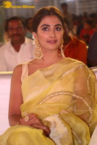 Actress Pooja Hegde in a yellow saree while attending the pre-release event of the Telugu movie Acharya
