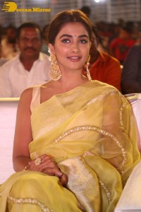 Actress Pooja Hegde in a yellow saree while attending the pre-release event of the Telugu movie Acharya