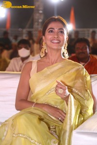 Actress Pooja Hegde in a yellow saree while attending the pre-release event of the Telugu movie Acharya