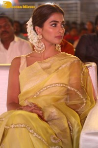 Actress Pooja Hegde in a yellow saree while attending the pre-release event of the Telugu movie Acharya