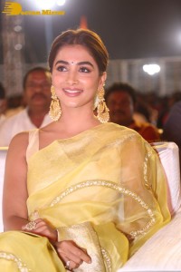 Actress Pooja Hegde in a yellow saree while attending the pre-release event of the Telugu movie Acharya