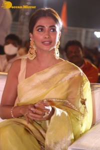 Actress Pooja Hegde in a yellow saree while attending the pre-release event of the Telugu movie Acharya