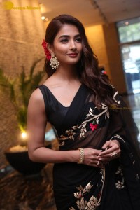 Pooja Hegde in a black saree while attending Acharya movie press meet