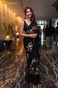 Pooja Hegde in a black saree while attending Acharya movie press meet