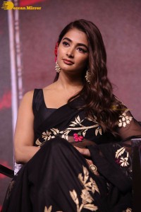 Pooja Hegde in a black saree while attending Acharya movie press meet