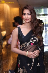 Pooja Hegde in a black saree while attending Acharya movie press meet