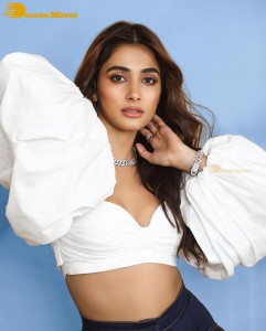 Actress Pooja Hegde in a white top and blue denim jeans