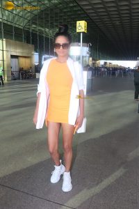 actress Poonam Pandey in a short orange dress at airport