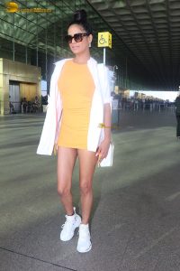 actress Poonam Pandey in a short orange dress at airport