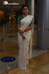 Actress Poorna in a white saree and green blouse posing for a photoshoot