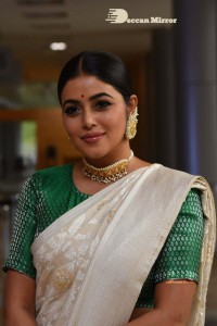 Actress Poorna in a white saree and green blouse posing for a photoshoot