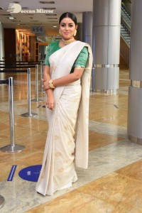Actress Poorna in a white saree and green blouse posing for a photoshoot