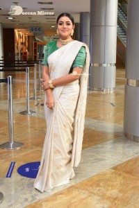 Actress Poorna in a white saree and green blouse posing for a photoshoot