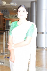 Actress Poorna in a white saree and green blouse posing for a photoshoot