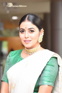 Actress Poorna in a white saree and green blouse posing for a photoshoot