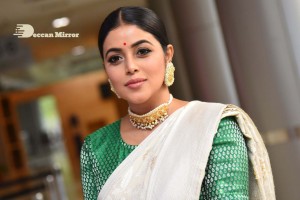 Actress Poorna in a white saree and green blouse posing for a photoshoot