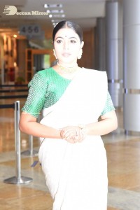 Actress Poorna in a white saree and green blouse posing for a photoshoot