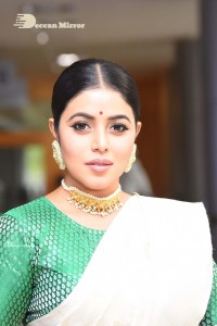 Actress Poorna in a white saree and green blouse posing for a photoshoot