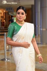 Actress Poorna in a white saree and green blouse posing for a photoshoot