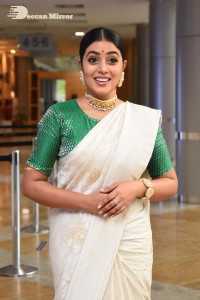 Actress Poorna in a white saree and green blouse posing for a photoshoot