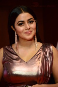 Actress Poorna in a shiny maroon dress