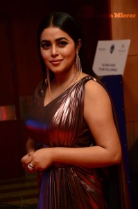 Actress Poorna in a shiny maroon dress