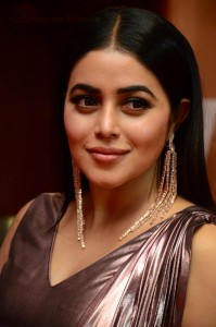 Actress Poorna in a shiny maroon dress