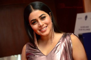 Actress Poorna in a shiny maroon dress