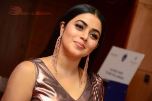 Actress Poorna in a shiny maroon dress