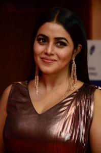 Actress Poorna in a shiny maroon dress