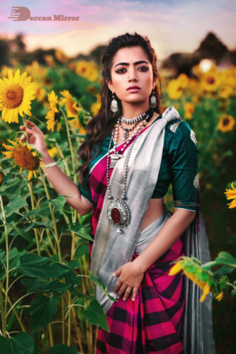 Kannada and Telugu Actress Rashmika Mandanna posing amongst flowers