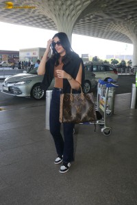 actress saiee manjrekar in a dark orange top and black jeans at airport
