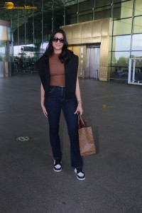 actress saiee manjrekar in a dark orange top and black jeans at airport