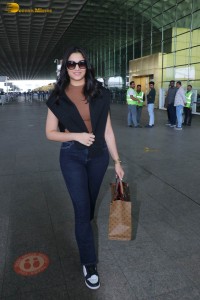 actress saiee manjrekar in a dark orange top and black jeans at airport